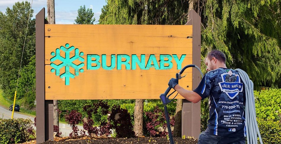 clean squad property services - team member standing in front of burnaby sign