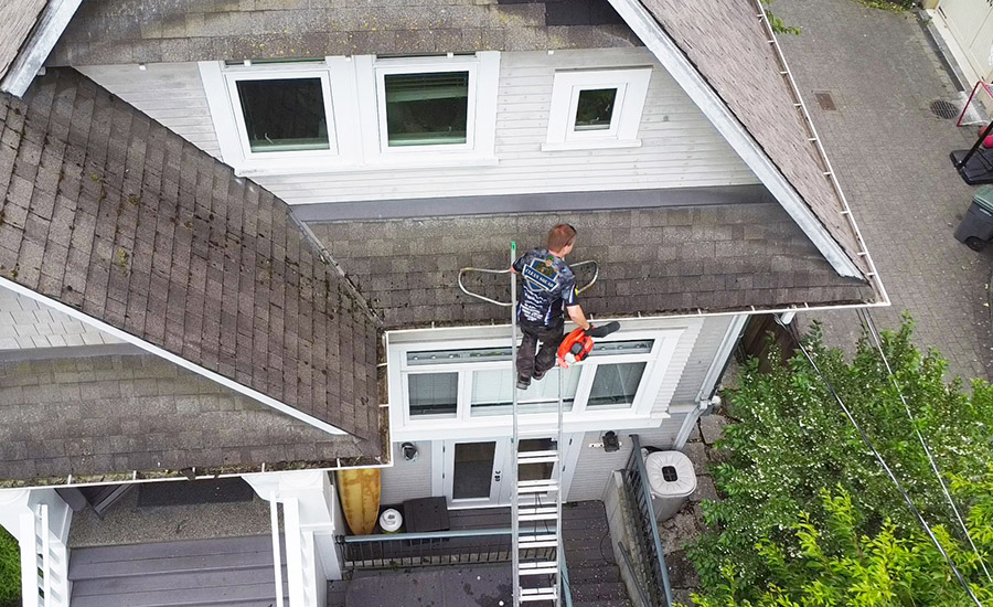 drone photo of a clean squad employee cleaning gutters on a home in kitsilano vancouver