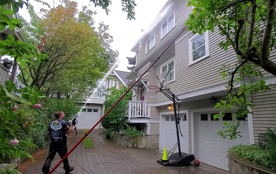 a clean squad employee soft washing siding on a townhouse complex in point grey vancouver