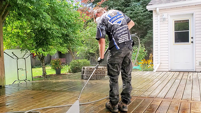 clean squad property services team member cleaning a deck