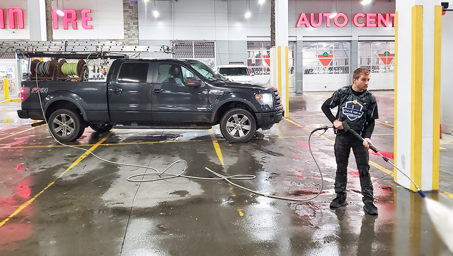 a team member cleaning concrete in canadian tire auto shop