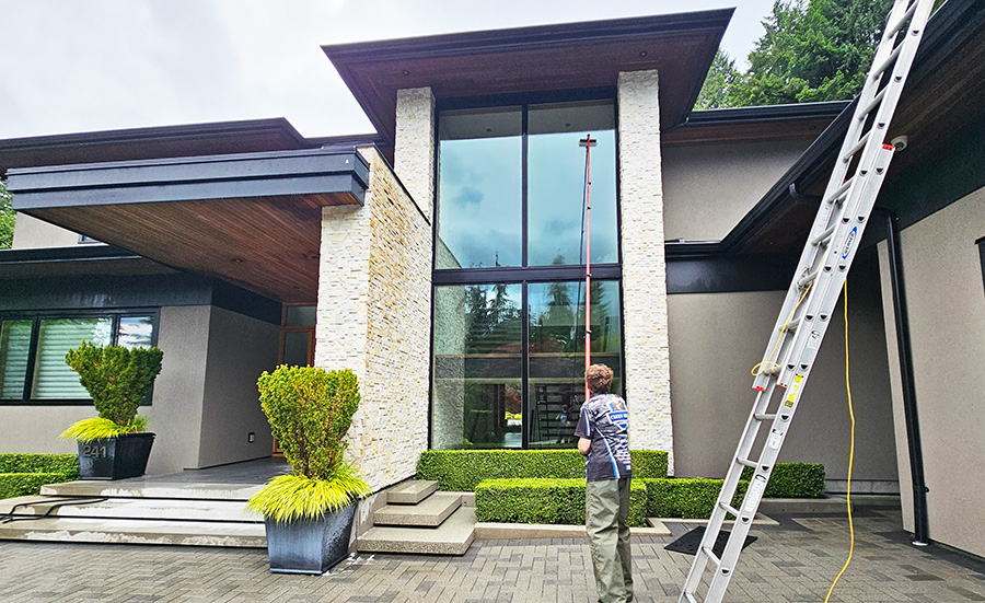 clean squad property services cleaning windows on luxury home